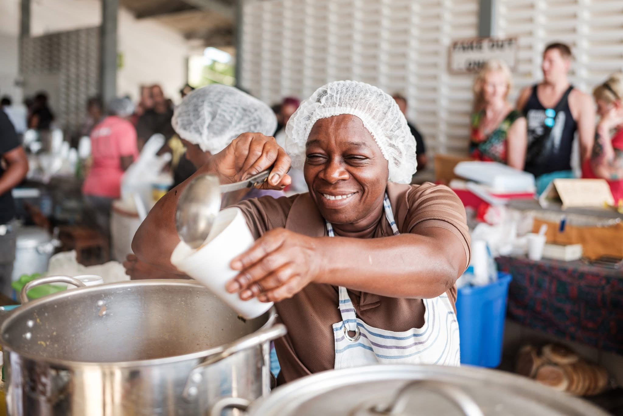 A cook serving home-style Curaçao food at a local market kitchen